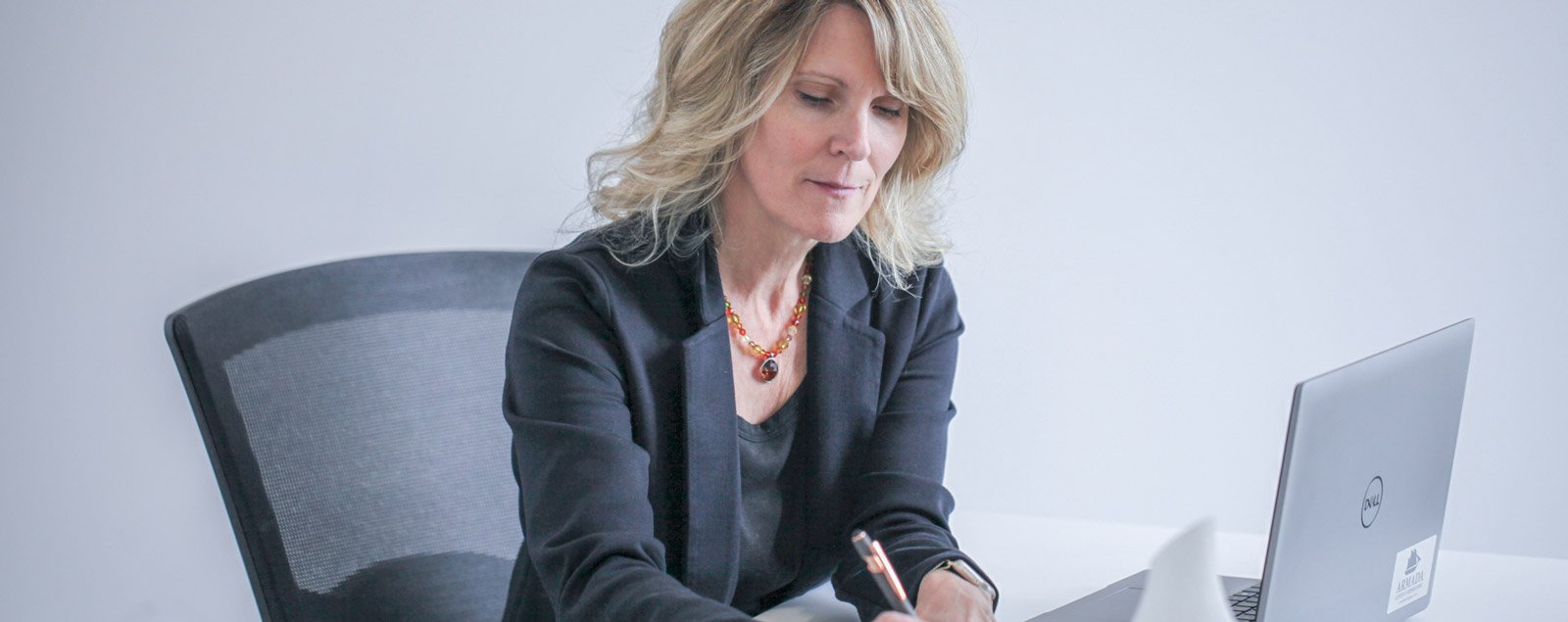 armada mortgage about hero karin signing documents at her desk